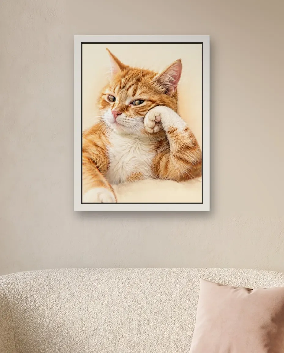 An orange cat's Soft Pastel portrait as a framed canvas on a bedroom wall above a cream loveseat