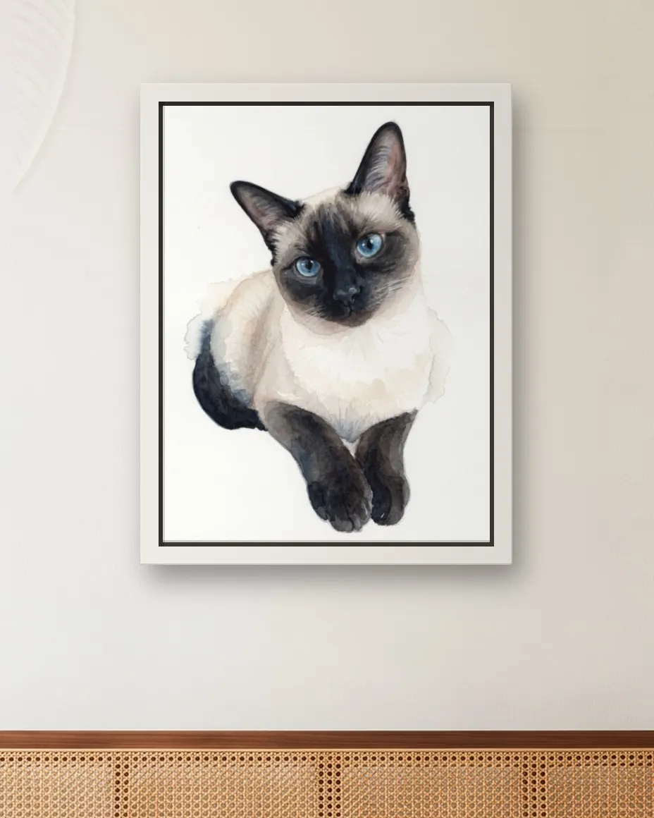 A Siamese cat's Soft Watercolor portrait as a framed canvas on a sunroom wall above a cane daybed