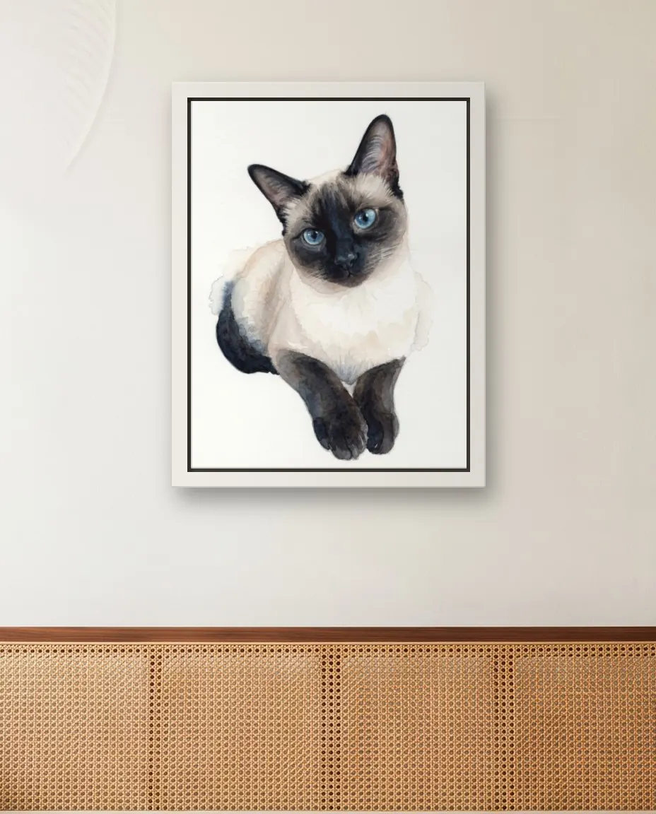 A Siamese cat's Soft Watercolor portrait as a framed canvas on a sunroom wall above a cane daybed